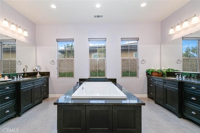 bathroom featuring tiled bath, tile patterned floors, and vanity