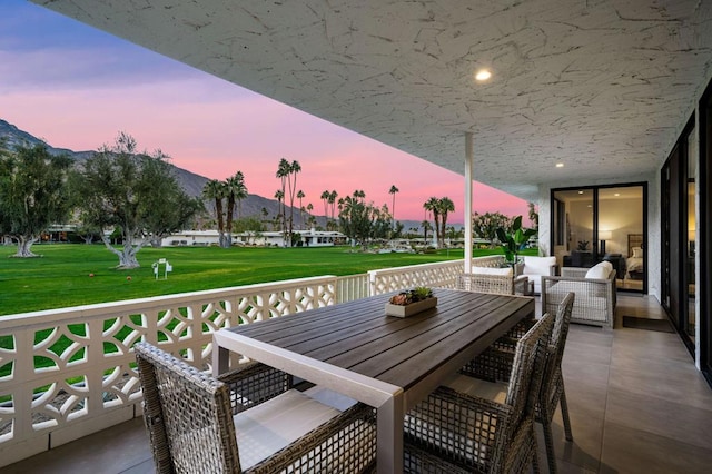 balcony at dusk featuring an outdoor hangout area and a patio