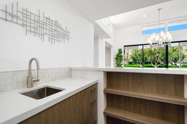 kitchen with a healthy amount of sunlight, a notable chandelier, sink, and pendant lighting