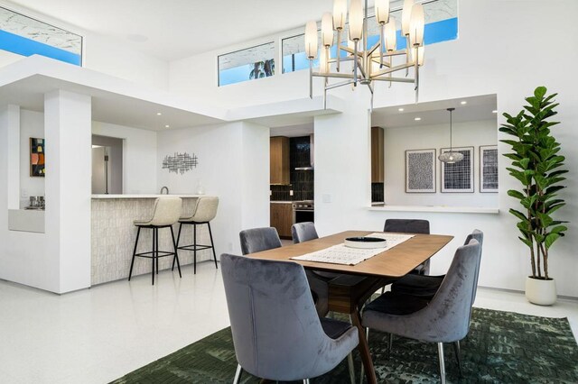 dining area featuring a notable chandelier and a high ceiling