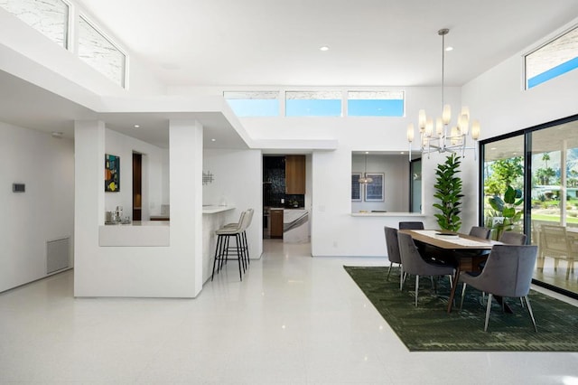 dining room with a towering ceiling and an inviting chandelier