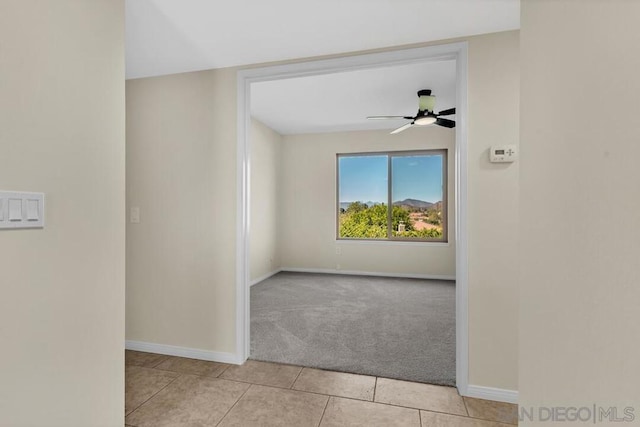 empty room featuring ceiling fan and light colored carpet