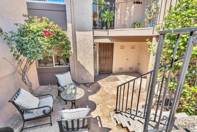 entrance to property featuring a patio area and a balcony