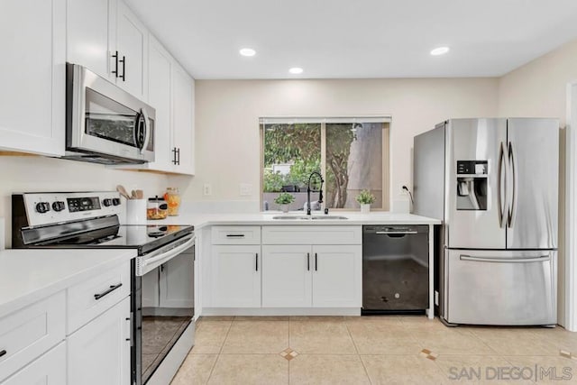 kitchen with white cabinets, appliances with stainless steel finishes, sink, and light tile patterned floors