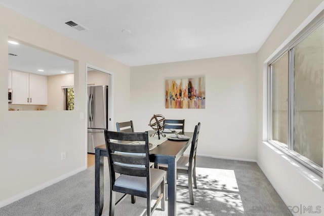 carpeted dining area featuring plenty of natural light