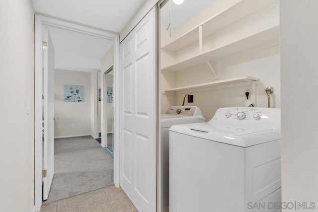 clothes washing area featuring light tile patterned flooring and independent washer and dryer