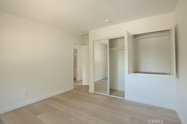 unfurnished bedroom with light hardwood / wood-style floors and a closet