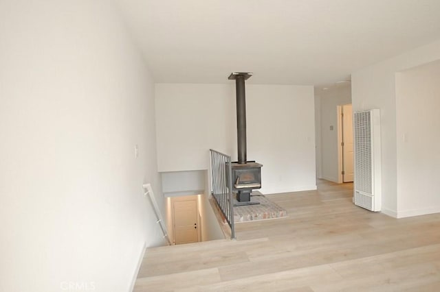 living room with a wood stove and light hardwood / wood-style floors