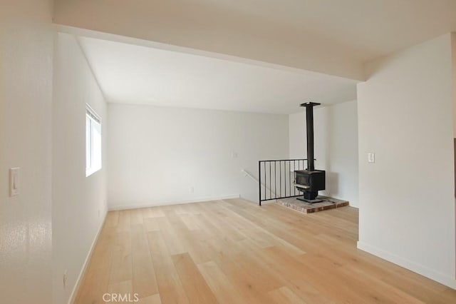 unfurnished living room with a wood stove and light hardwood / wood-style flooring