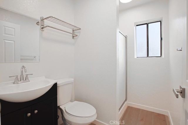 bathroom featuring vanity, toilet, wood-type flooring, and an enclosed shower