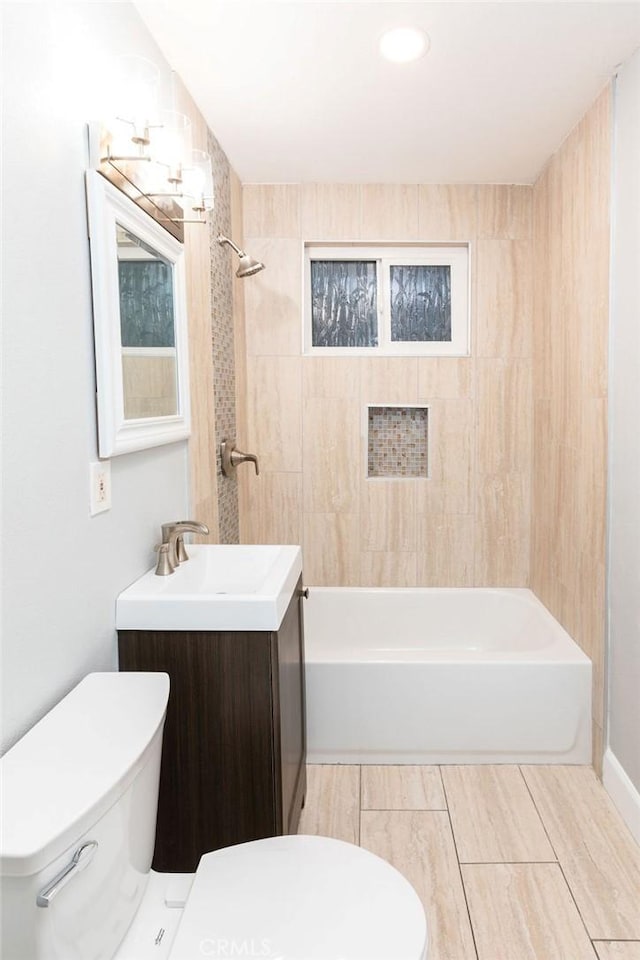 full bathroom featuring toilet, tiled shower / bath combo, and vanity