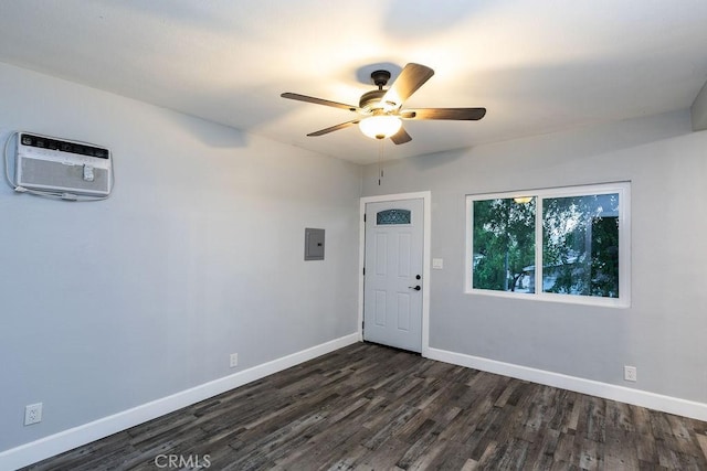 spare room featuring a wall unit AC, ceiling fan, electric panel, and dark hardwood / wood-style flooring