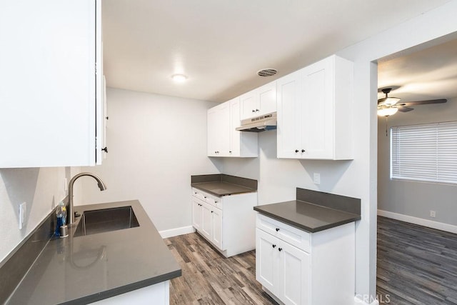 kitchen featuring premium range hood, ceiling fan, dark wood-type flooring, white cabinets, and sink