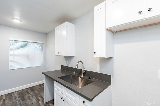 kitchen featuring dark wood-type flooring, sink, and white cabinets