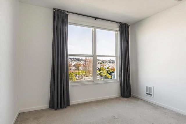 spare room featuring light carpet