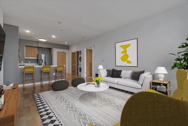 living room featuring light hardwood / wood-style flooring and stacked washer / dryer