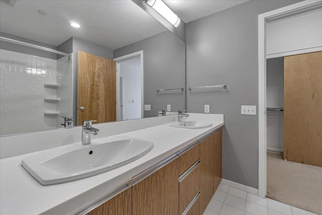 bathroom featuring tile patterned flooring, vanity, and walk in shower