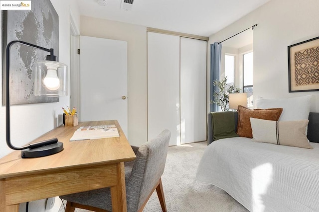 bedroom featuring light colored carpet and a closet