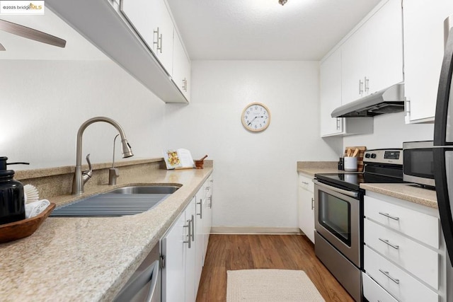 kitchen with stainless steel range with electric cooktop, light hardwood / wood-style flooring, white cabinets, and sink