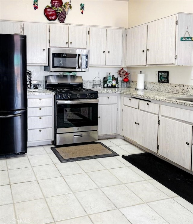 kitchen with light tile patterned floors and stainless steel appliances