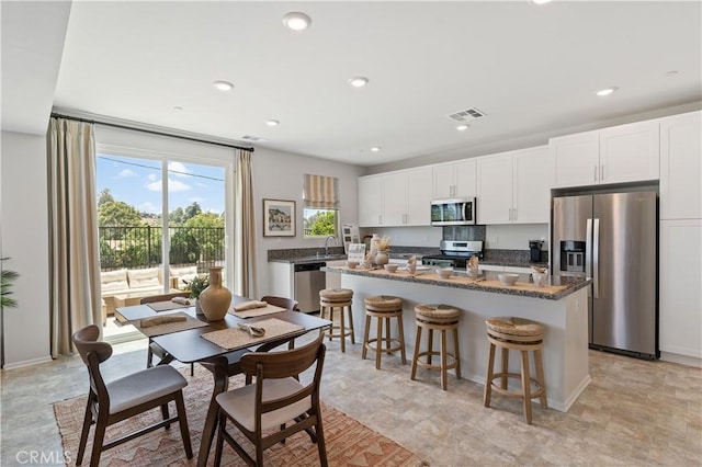 34273 Creek View Ln, Yucaipa, CA 92399 - kitchen featuring appliances with stainless steel finishes, a center island, white cabinets, a breakfast bar area, and recessed lighting