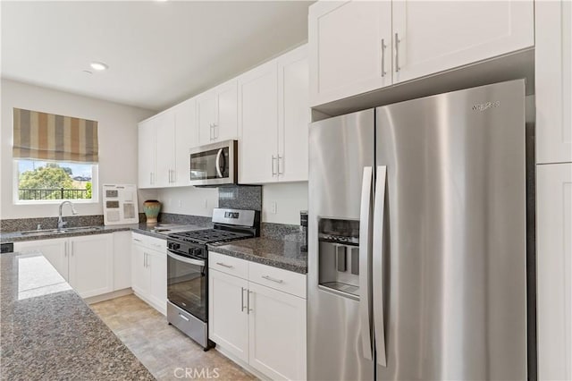 34273 Creek View Ln, Yucaipa, CA 92399 - kitchen with appliances with stainless steel finishes, a sink, dark stone counters, white cabinets, and recessed lighting