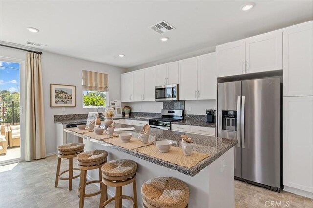 34273 Creek View Ln, Yucaipa, CA 92399 - kitchen with appliances with stainless steel finishes, a kitchen breakfast bar, white cabinets, a kitchen island, and recessed lighting