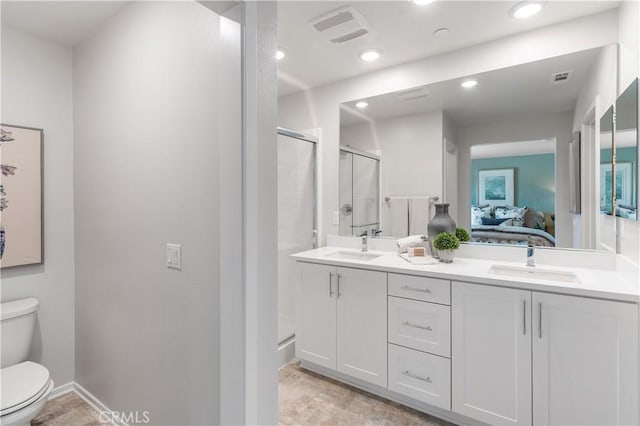 bathroom with toilet, a shower with door, and sink