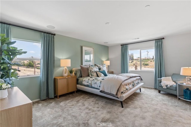 bedroom featuring multiple windows and light carpet