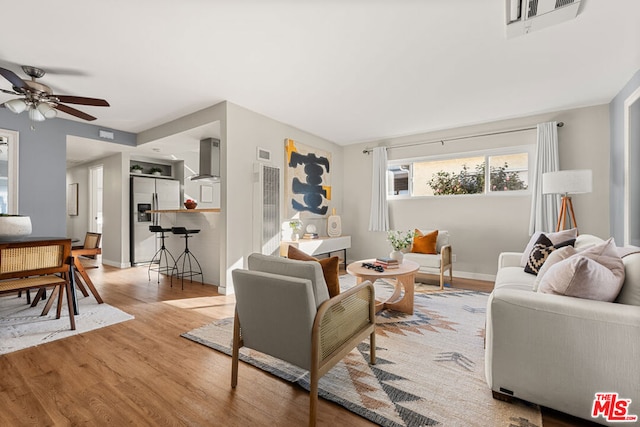 living room featuring ceiling fan and light hardwood / wood-style floors