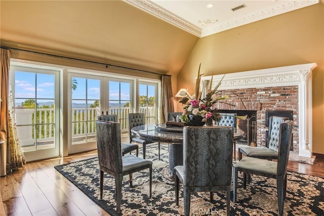 dining area with vaulted ceiling, french doors, ornamental molding, and wood-type flooring