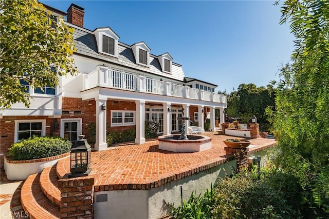 back of house with a balcony and a patio