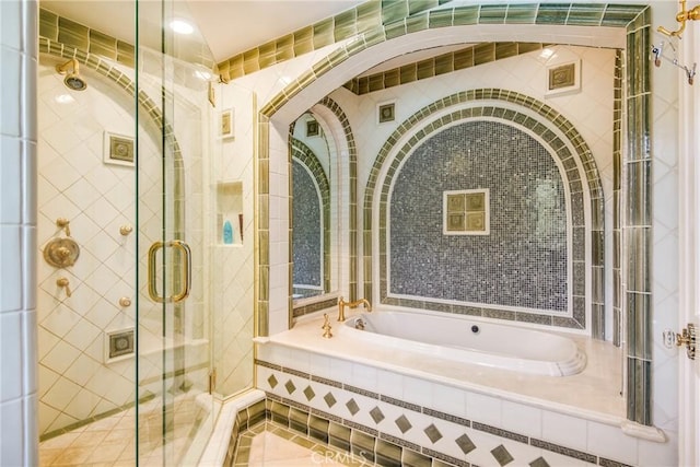 bathroom featuring shower with separate bathtub and tile walls