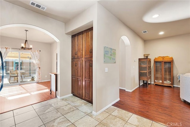 tiled foyer entrance with a chandelier