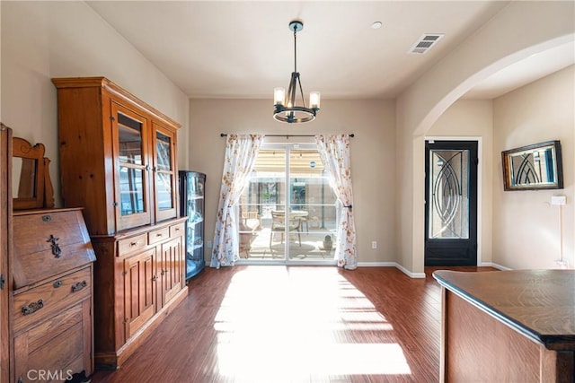 entrance foyer featuring dark hardwood / wood-style flooring and an inviting chandelier