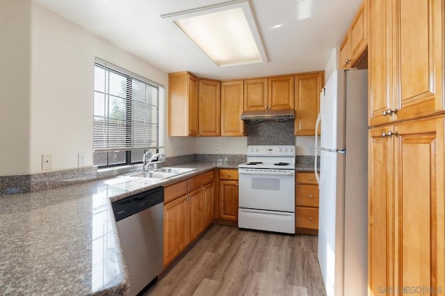 kitchen featuring dark stone countertops, decorative backsplash, wood-type flooring, sink, and white appliances