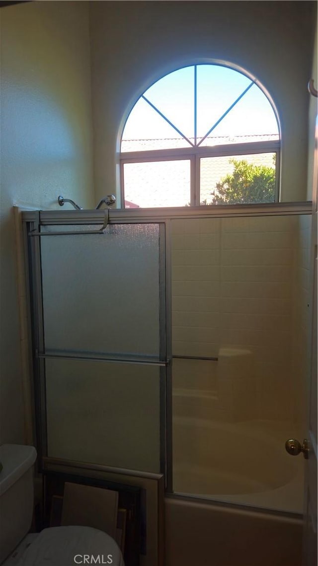 bathroom featuring toilet and enclosed tub / shower combo