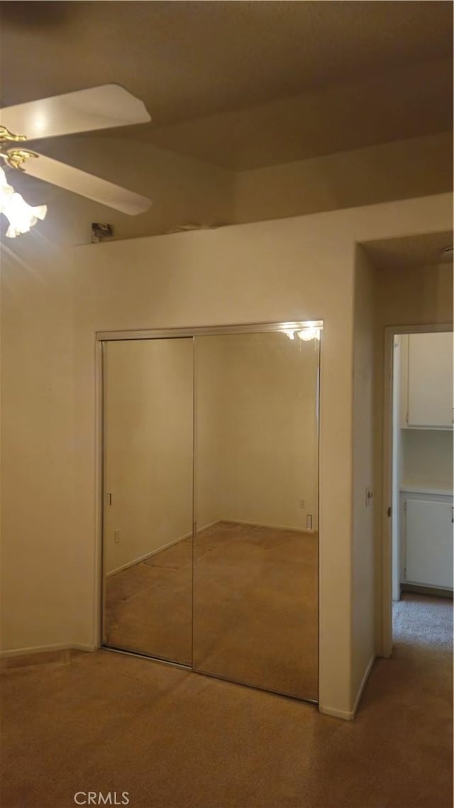 interior space with ceiling fan, carpet, and a closet