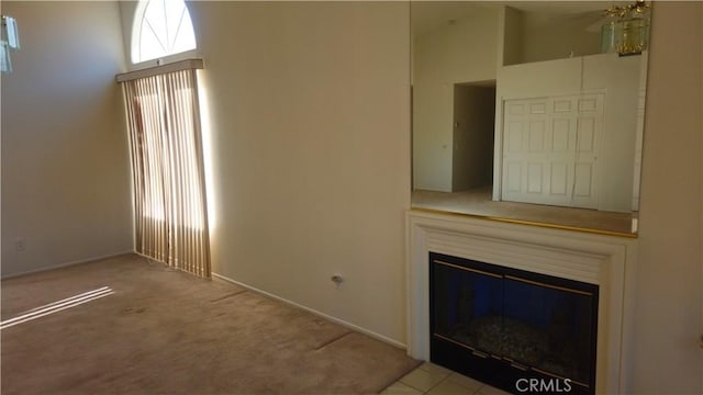 unfurnished living room with a high ceiling and light colored carpet