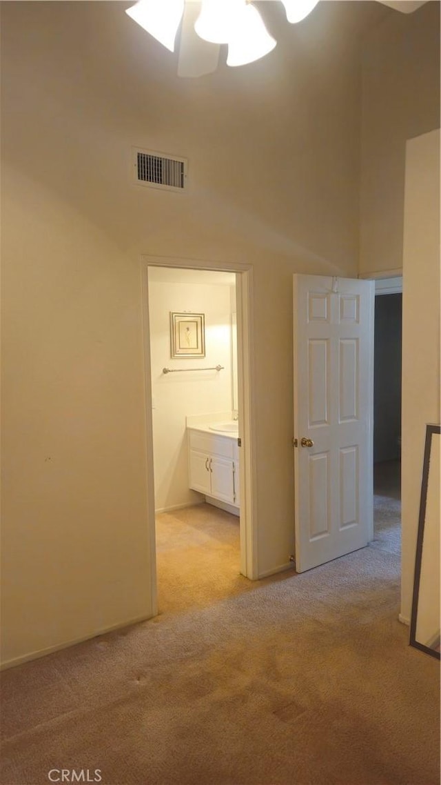 interior space with ceiling fan and light carpet