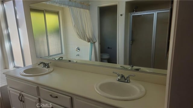 bathroom featuring toilet, an enclosed shower, and vanity