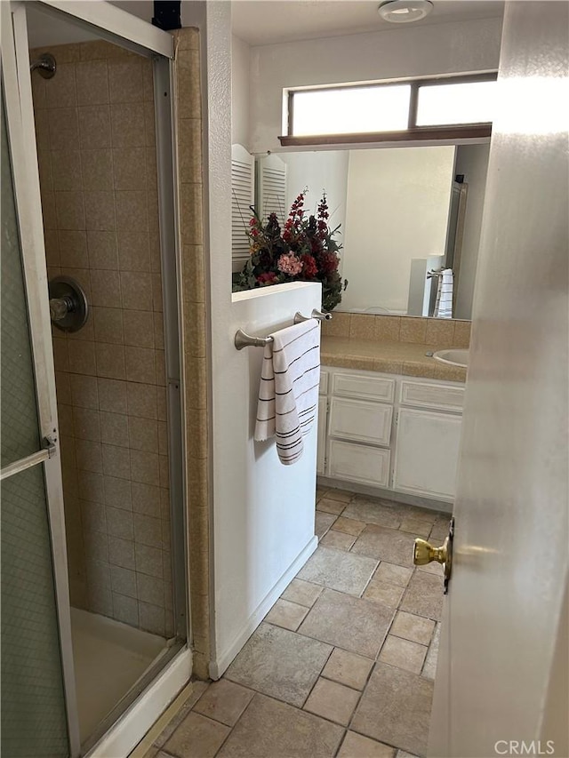 bathroom with a shower stall and vanity