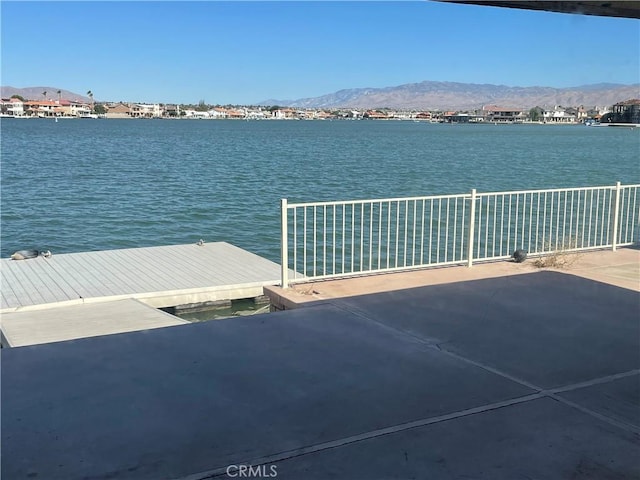 view of dock with a water and mountain view