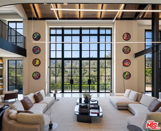 living room featuring wood ceiling and a high ceiling