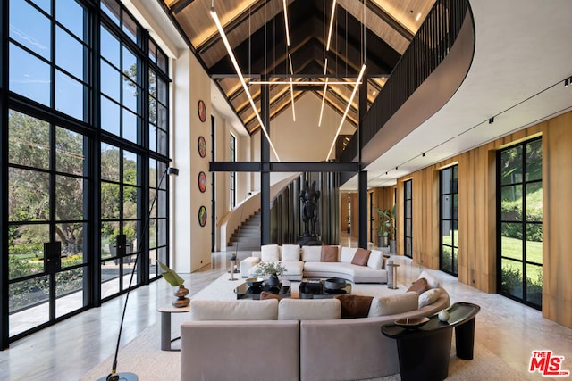 living room featuring high vaulted ceiling, wooden ceiling, beam ceiling, and wooden walls