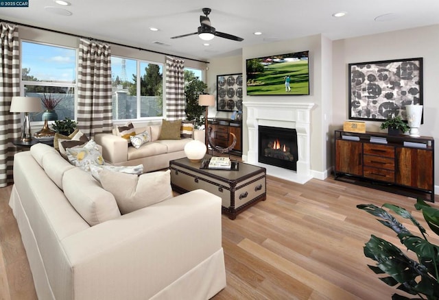 living room with ceiling fan and light hardwood / wood-style flooring