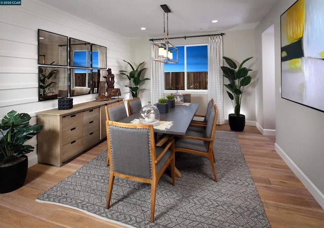 dining area featuring light hardwood / wood-style flooring and a notable chandelier