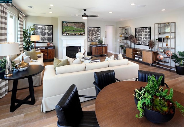 living room featuring light hardwood / wood-style floors and ceiling fan