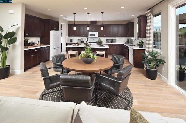 dining room featuring light wood-type flooring and sink