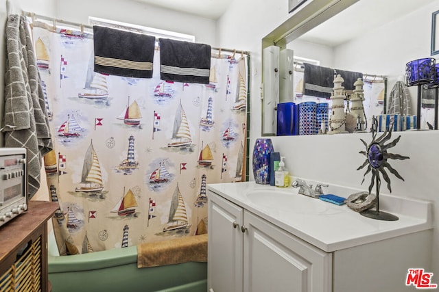 bathroom featuring shower / tub combo and vanity